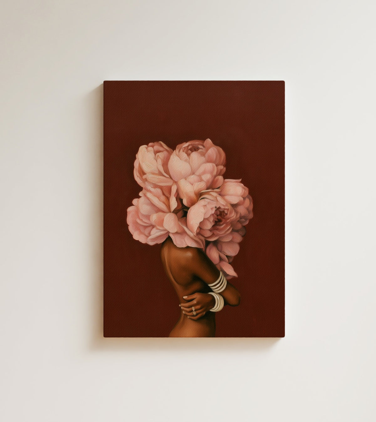In Full Bloom: A woman seen from behind, her head a bouquet of blush pink peonies, on a deep burgundy background. Canvas wall art, shown on a plain wall