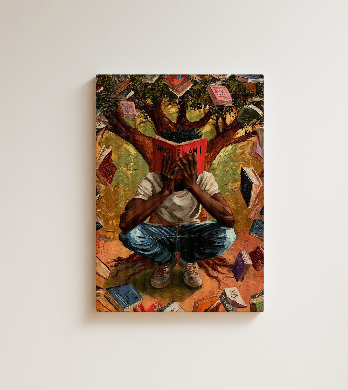 Who Am I: A Black man sits cross-legged beneath a tree inside a storm of open books. Canvas wall art, shown on a plain wall
