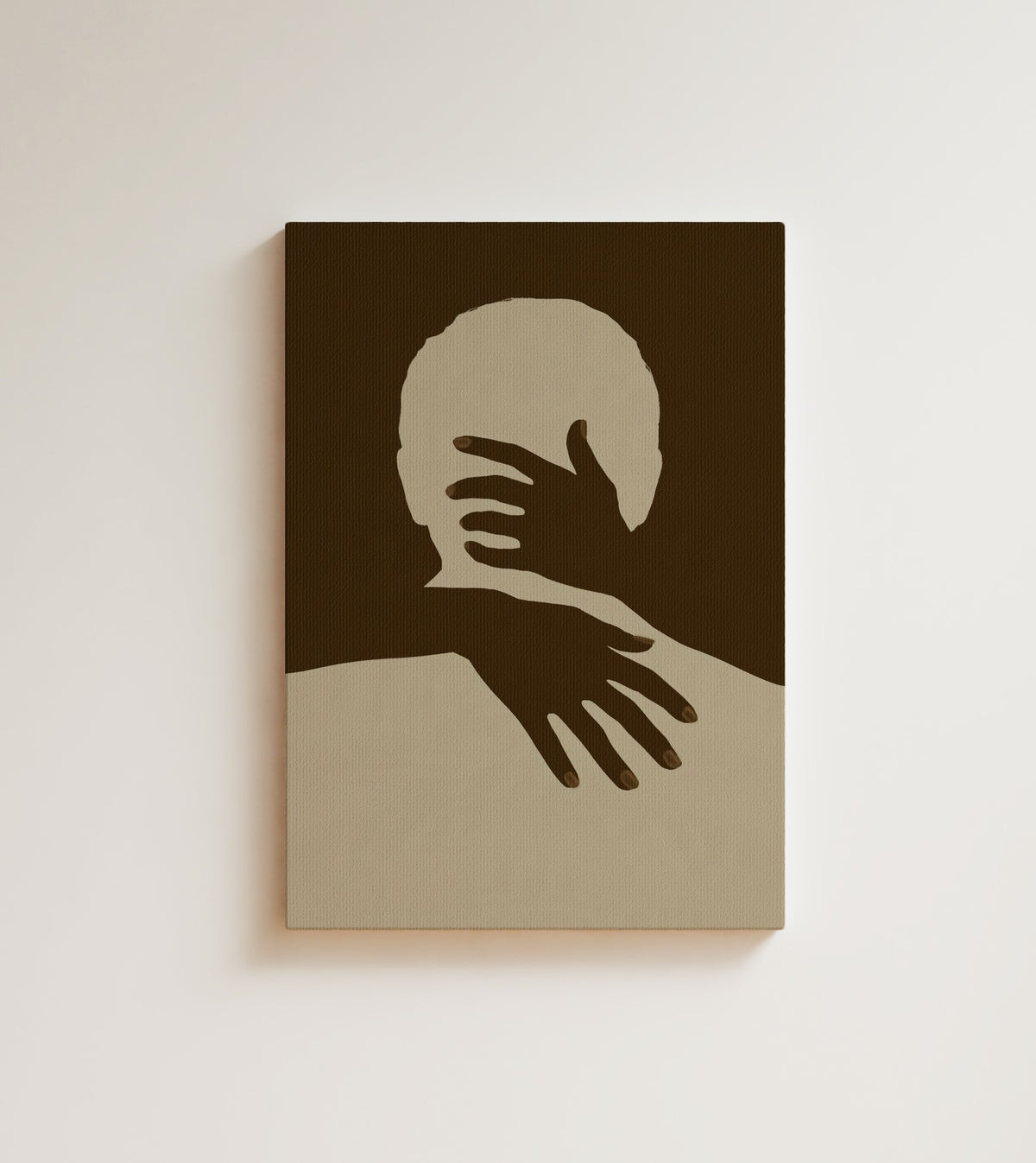 Held: A cream silhouette held close by two dark brown hands, one across the face and one over the shoulder. Canvas wall art, shown on a plain wall