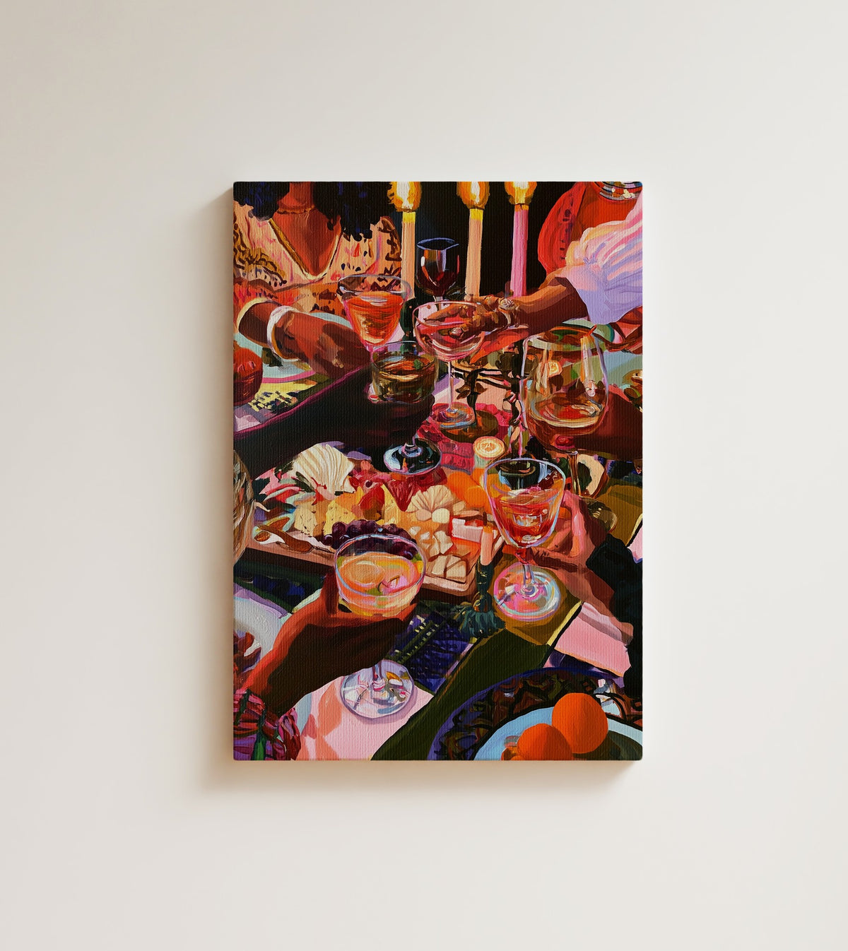 Candles and Company: A dinner party seen from above, hands crossing over wine glasses, a grazing board. Canvas wall art, shown on a plain wall