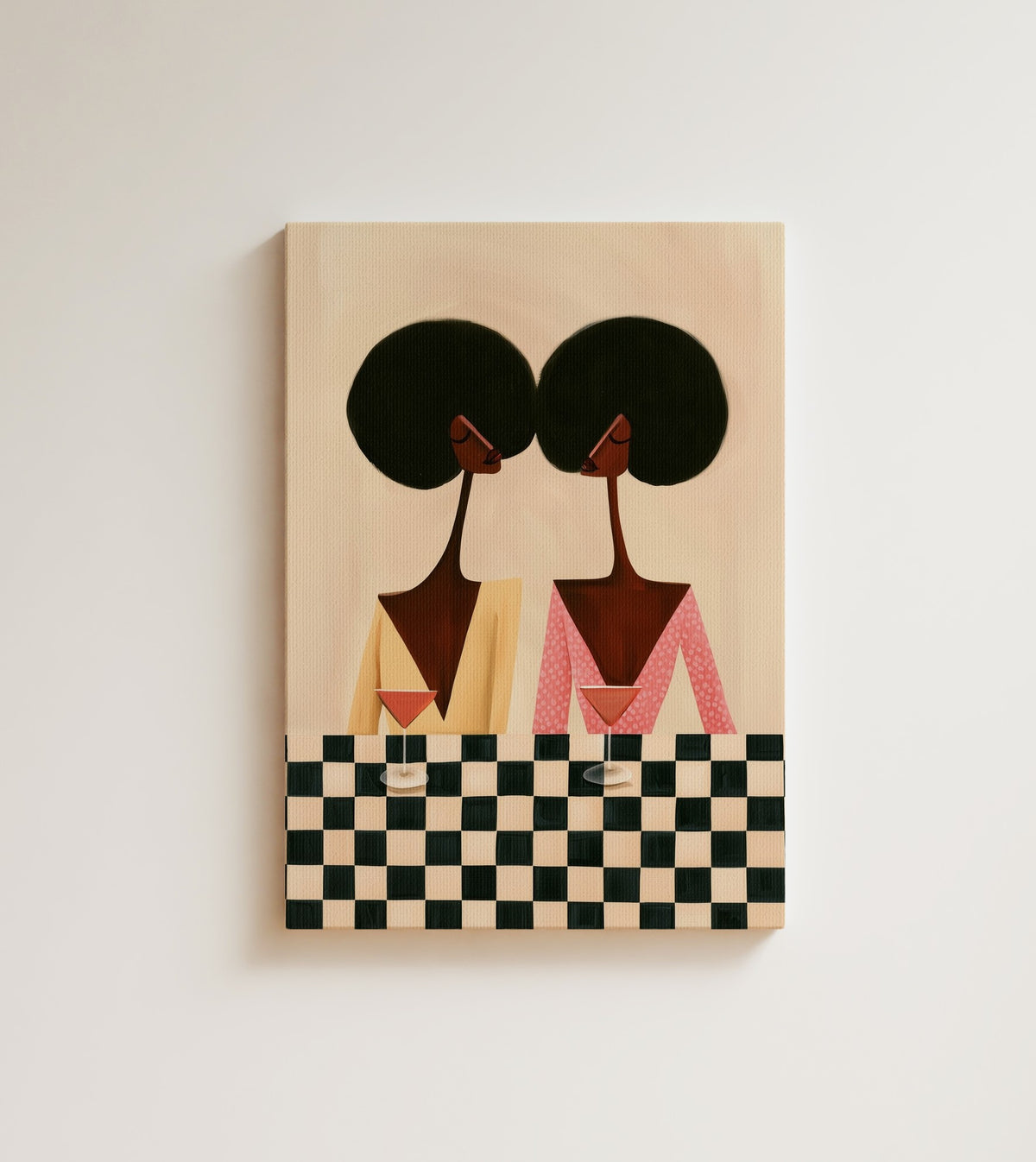 The Checkered Table: two friends lift martini glasses across a checkered table against a warm ivory wall. Canvas wall art, shown on a plain wall