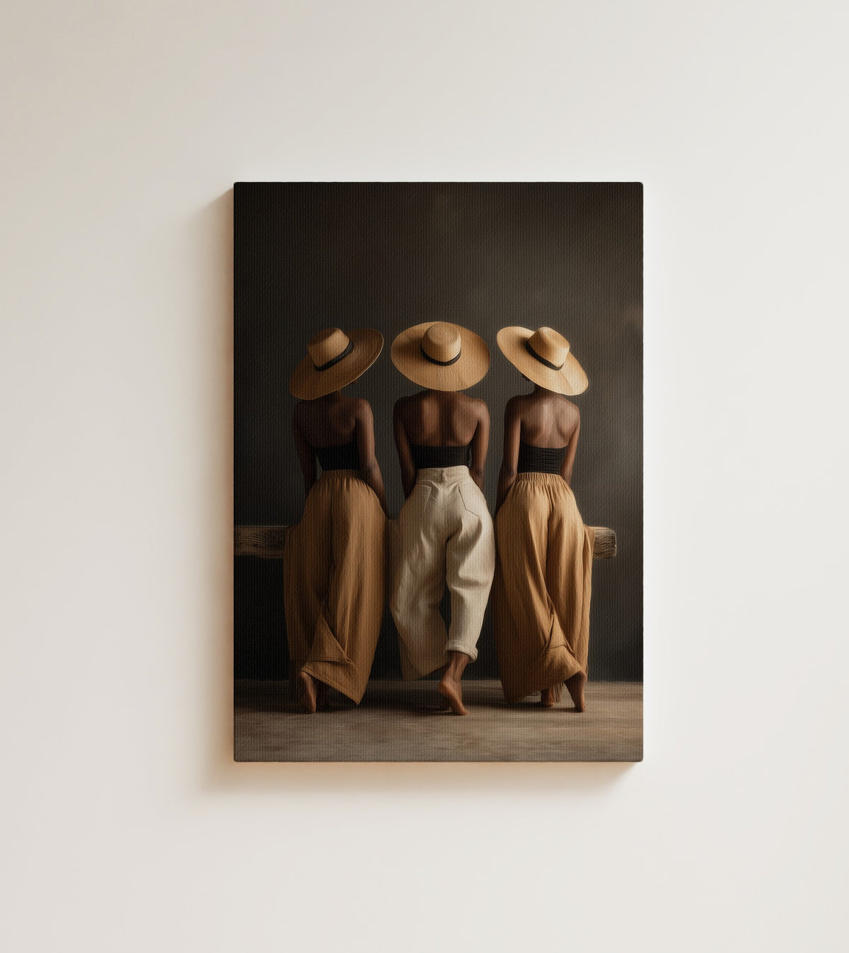 Three Brims: three Black women stand together in wide straw hats and flowing linen. Canvas wall art, shown on a plain wall
