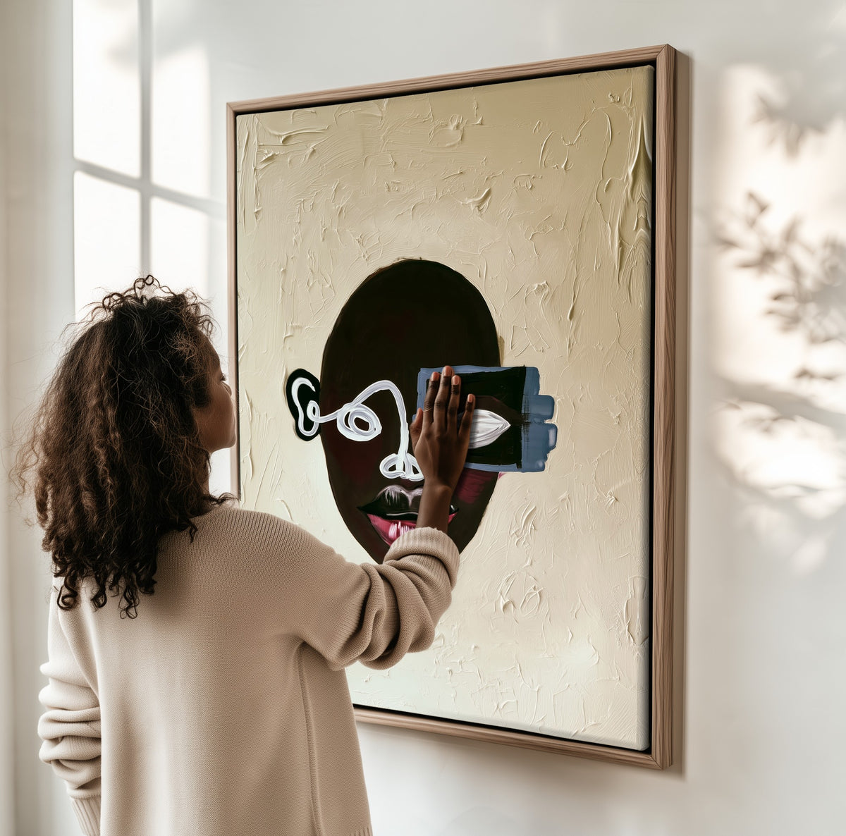 Half Seen framed canvas, a woman hanging it on a sunlit wall