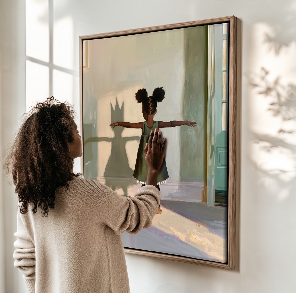 The Crowned Shadow framed canvas, a woman hanging it on a sunlit wall