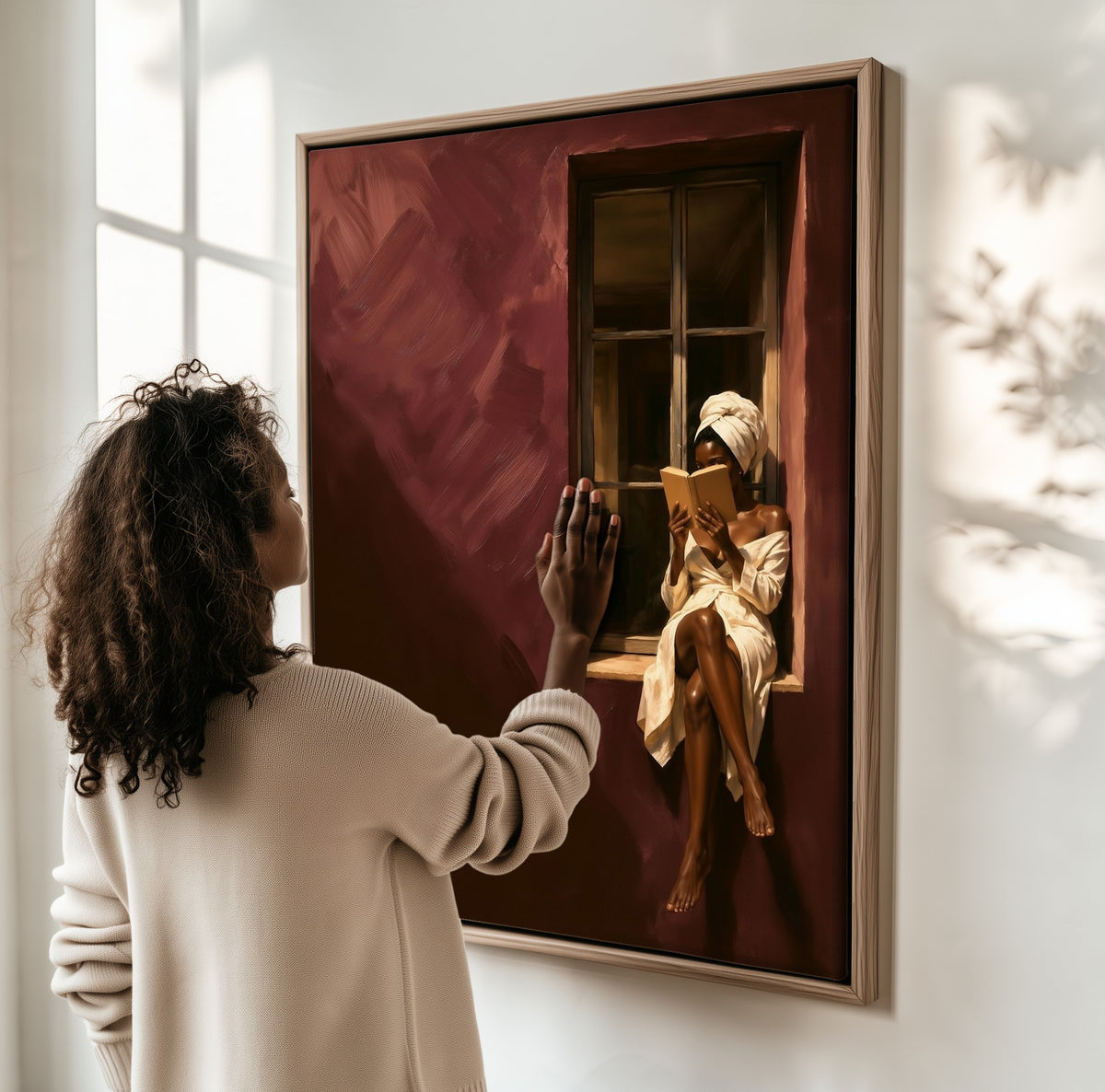 Reader in Burgundy framed canvas, a woman hanging it on a sunlit wall