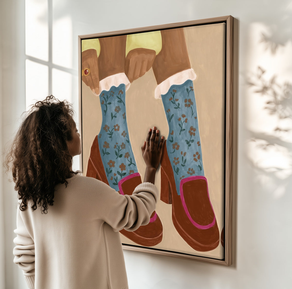 Study in Floral Socks framed canvas, a woman hanging it on a sunlit wall