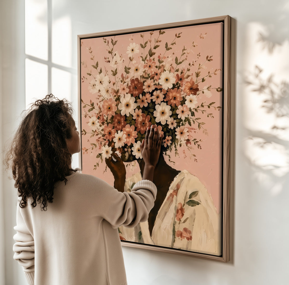Full Bloom framed canvas, a woman hanging it on a sunlit wall