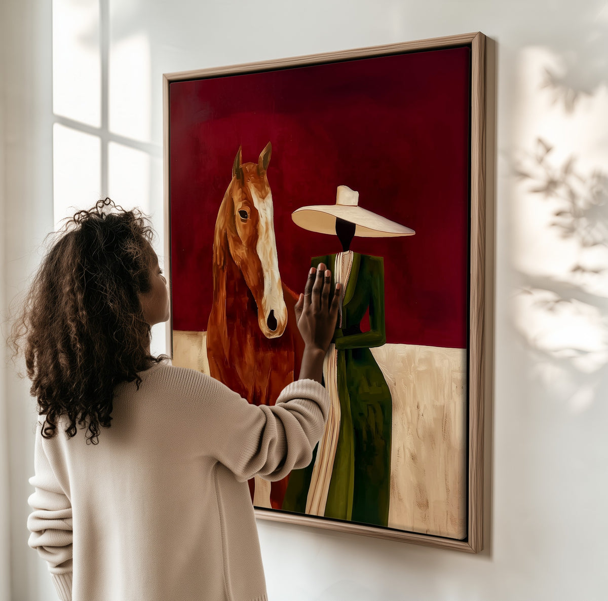 The Chestnut Horse framed canvas, a woman hanging it on a sunlit wall