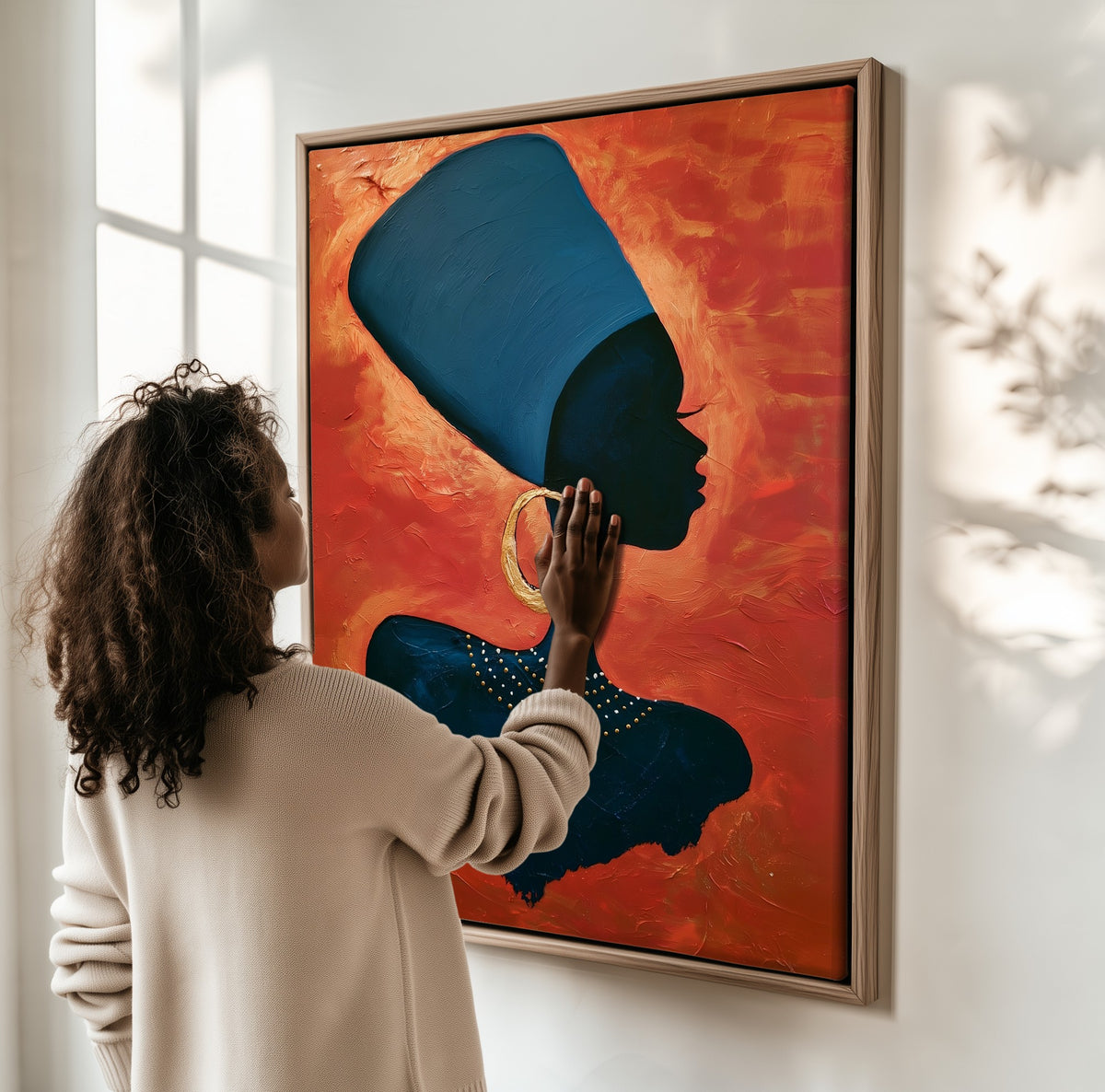 Blue Wrap framed canvas, a woman hanging it on a sunlit wall