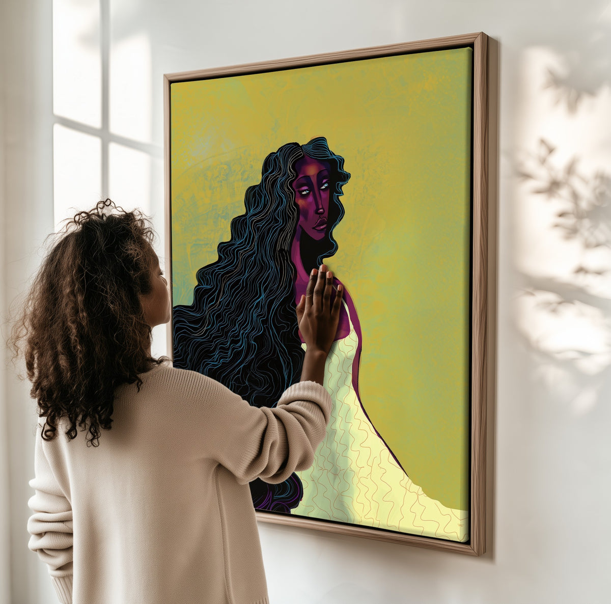 Undertow framed canvas, a woman hanging it on a sunlit wall