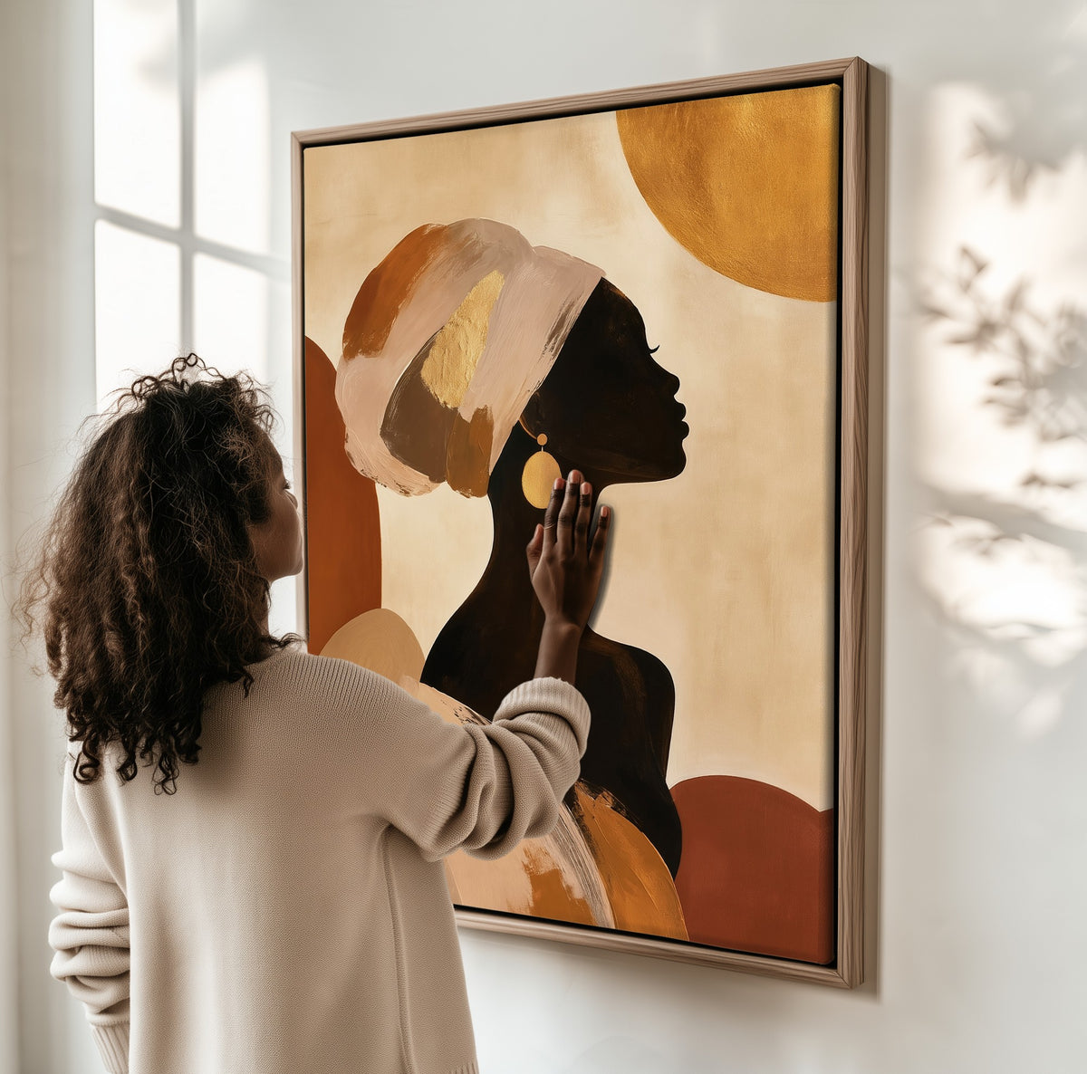 Sun Behind Her framed canvas, a woman hanging it on a sunlit wall