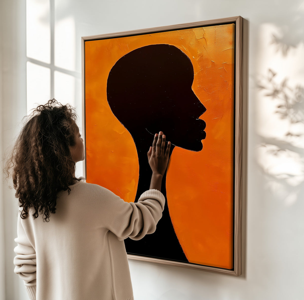 Solitude framed canvas, a woman hanging it on a sunlit wall