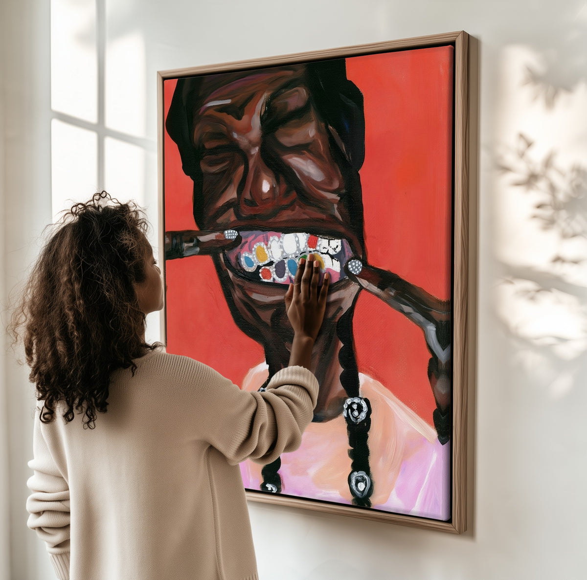 The Grin framed canvas, a woman hanging it on a sunlit wall