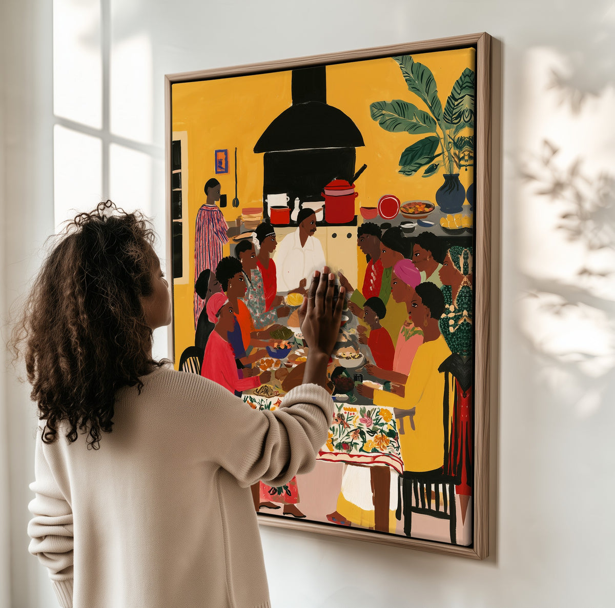 Everyone at the Table framed canvas, a woman hanging it on a sunlit wall
