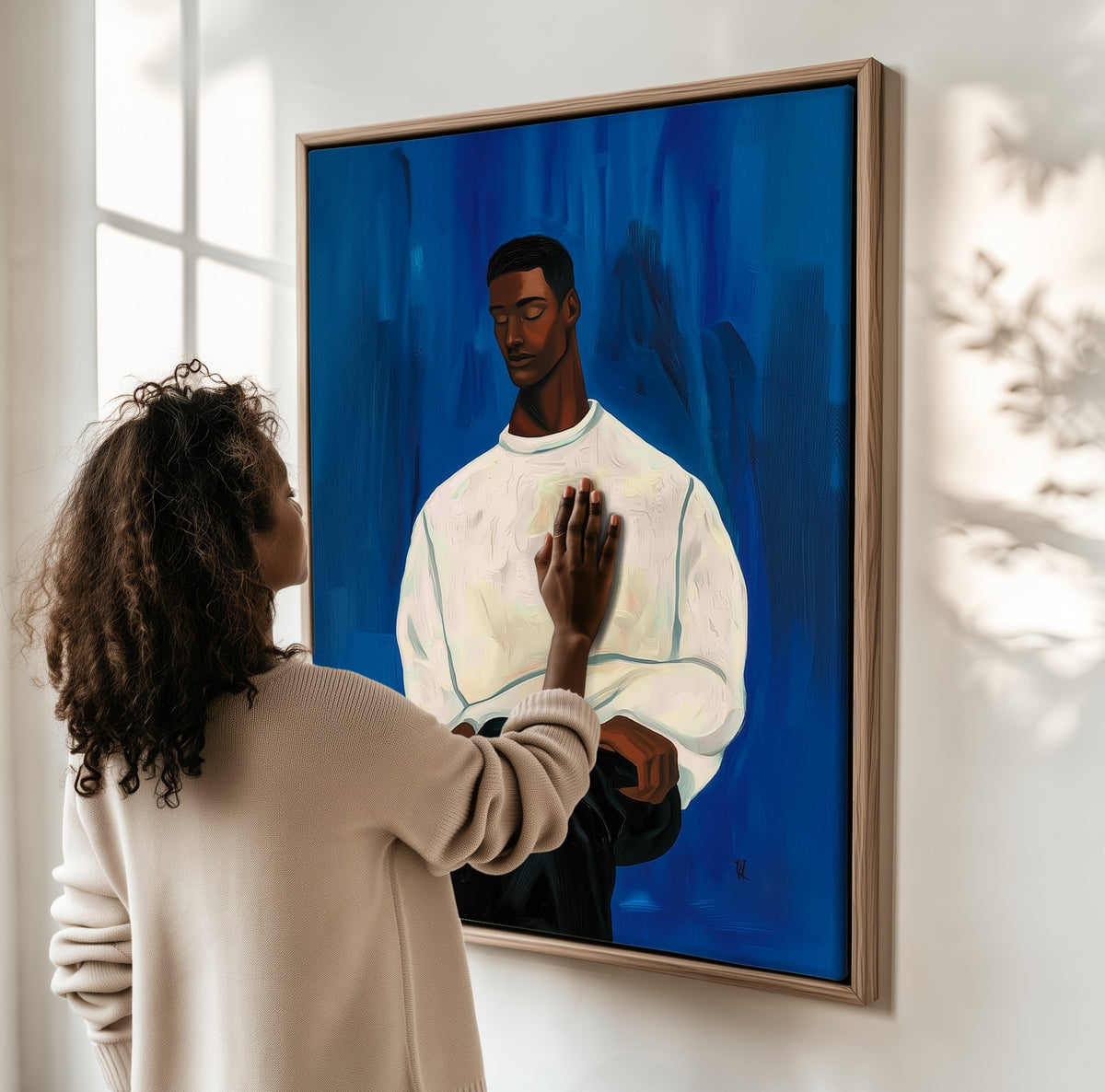 The White Sweater framed canvas, a woman hanging it on a sunlit wall