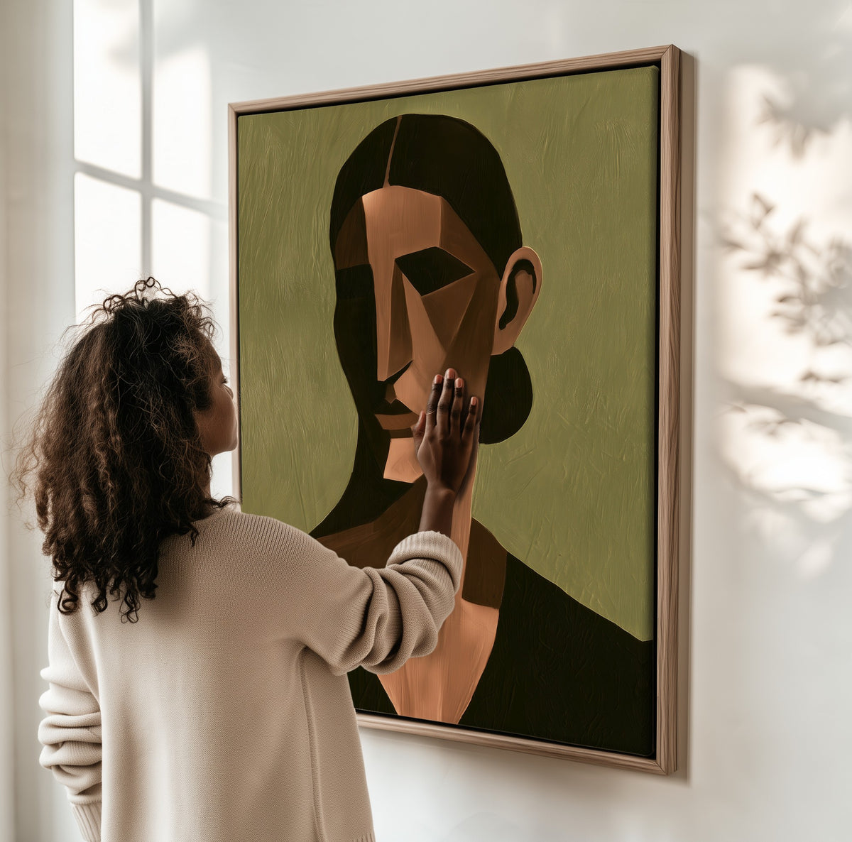Quiet Geometry framed canvas, a woman hanging it on a sunlit wall