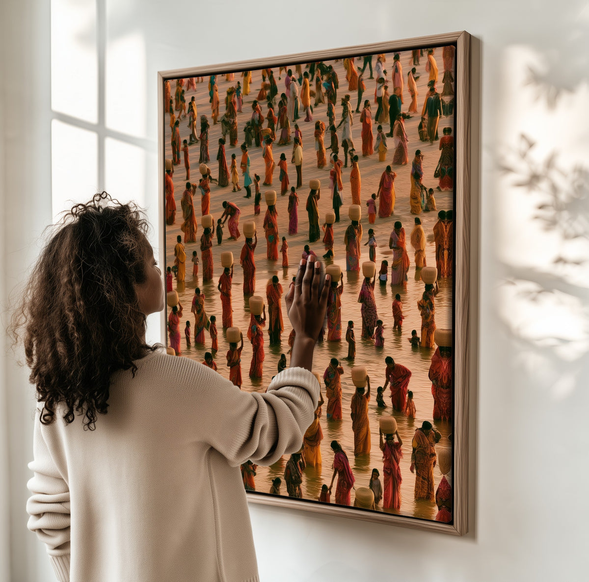 The Water Carriers framed canvas, a woman hanging it on a sunlit wall